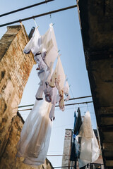 After washing, the laundry hangs on a line in the old inner courtyard. Traditional Ukrainian red and white embroidered shirts (vyshivanka) in Lviv.
