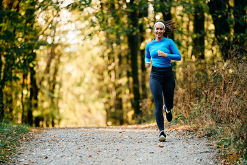 Fototapeta na wymiar Happy female athlete jogging while exercising in nature.