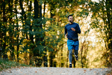 Happy athlete jogging while during his sports training in nature.
