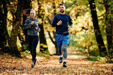 Full length of athletes running in nature in autumn day, - obrazy, fototapety, plakaty