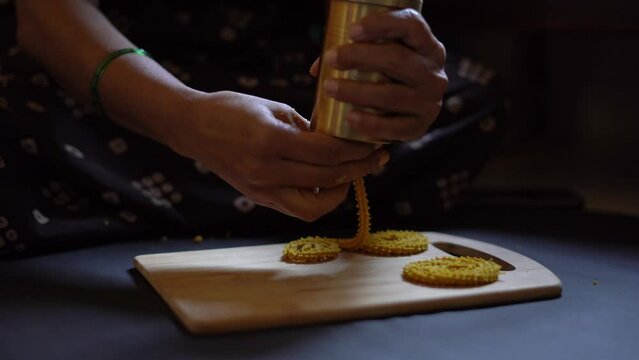 Indian woman making chakli an Diwali snack for Diwali festival 