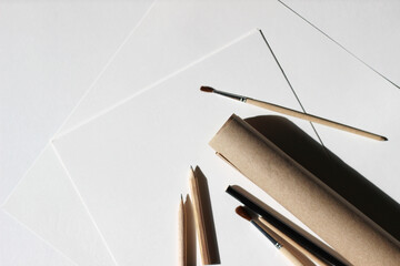 Design Studio Flatlay. Kraft Paper Roll, Sheets of Paper, Graphite Pencils, Small Painting Brushes...
