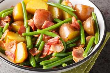 Salade Liegeoise Belgian salad with potatoes, bacon and green beans closeup on the plate on the table. Horizontal