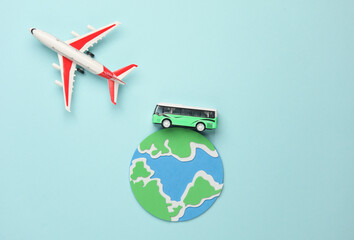 Toy bus miniature and air plane, globe on a blue background.Travel concept