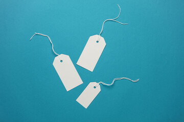 Set of blank white tags with ropes on blue background. Mock up, Template for design. Copy space. Sale, shopping concept