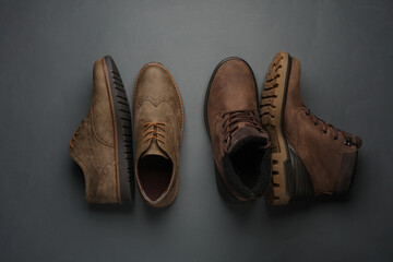 Leather boots and brogue shoes on a dark gray background. Top view
