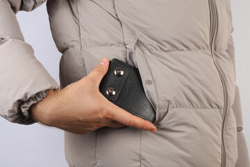 Leather wallet in the pocket of a man's down jacket