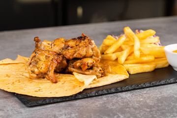 Chicken kebab with vegetables, fries and sauce on lavash