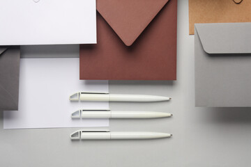Floating envelopes and cards, pens on gray background with shadow. Minimalism, modern business still life, creative layout
