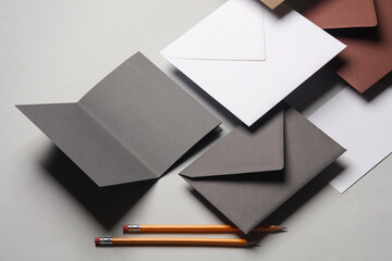 Floating envelopes and brochure, card, pens on gray background with shadow. Minimalism, modern...