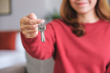 Closeup image of a woman holding the keys for real estate concept - obrazy, fototapety, plakaty