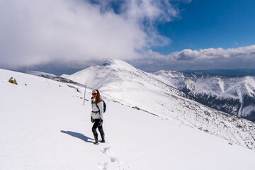 Naklejka na ściany i meble Female hiker aproaching summit of Low Tatry in deep snow and high wind, Tatras mountains in Slovakia Europe