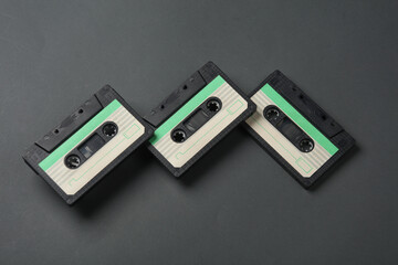 Floating retro 80s audio cassettes on a dark gray background. Conceptual pop, creative layout. Minimalism