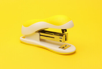 Plastic stapler on yellow background