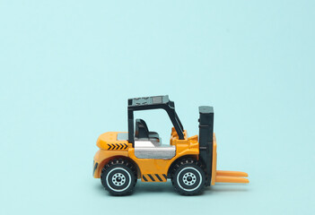 Miniature toy forklift on a blue background