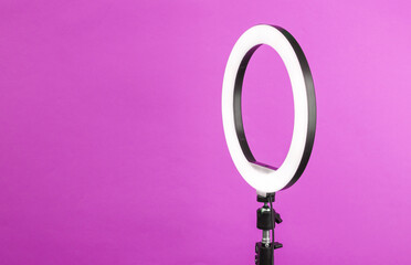 Led ring lamp on tripod, purple background