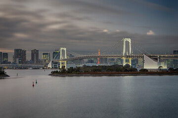 Japan Travel Destinations. View of Rainbow Bridge in Odaiba Island in Tokyo At Twilight with Line of Skyscrapers