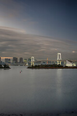 Japan Travel Destinations. View of Rainbow Bridge in Odaiba Island in Tokyo At Twilight with Line of Skyscrapers