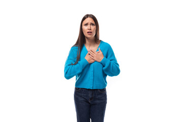 Fototapeta premium surprised young brunette lady dressed in blue casual button up cardigan on white background