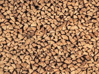 Large pile of stacked, chopped firewood