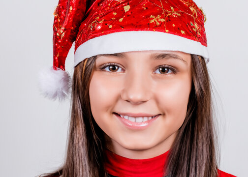 クリスマスのイメージの人物写真、サンタクロースの帽子をかぶった若い笑顔の白人女性　白背景
