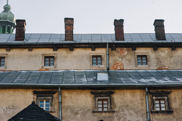 Walls and roof of an old house with windows. Fragment of the Church of St. Andrew from the back...