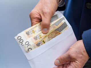Wyciągane pieniądze w polskiej walucie z papierowej koperty  - obrazy, fototapety, plakaty