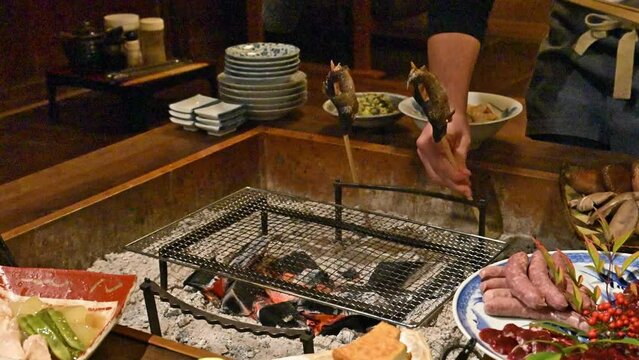 旅館などの旅行の食事で囲炉裏で魚を焼くところの動画