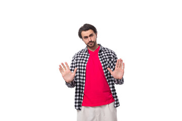 Portrait of a caucasian handsome man with a beard and styled hair stands thoughtfully on a white background with copy space