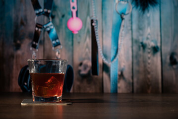 Glass of whiskey on the bar in front of the blur image Bondage, kinky adult sex games, kink and...
