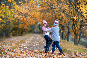 glücklich lachende Kinder tanzen im Herbst
