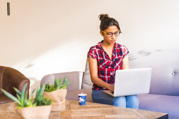 Concentrated woman using laptop working at home