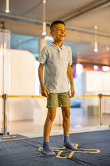 Little boy jumps on a playground intercating with learning models, visiting a science museum. Concept of children's entertainment and learning