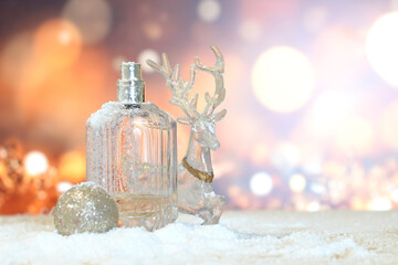 festive background of blurred lights in shades of gold with Christmas toys, deer, ball and perfume...