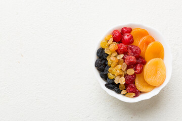 Bowl with different dried fruits on table background, top view. Healthy lifestyle with copy space