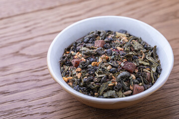Dried natural large tea leaves close up. Gunpowder green tea with strawberry pieces and tea rose petals.
