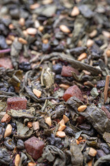 Dried natural large tea leaves close up. Gunpowder green tea with strawberry pieces and tea rose petals.