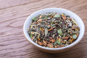 Dried natural large tea leaves close up. Crushed Sudanese rose flowers, chopped mint and raspberry leaves, currant and lingonberry leaves, tea rose petals, apple pieces.