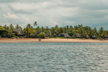 Man and a woman walking on a beach against resorts at Manda Isalnd in Kenya