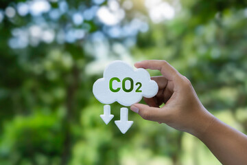 Reduce emission and Carbon neutral concept. Hand holding a CO2 icon symbol to limit climate change...