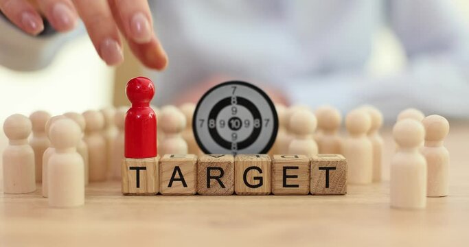 Hand places a red human figurine and word target