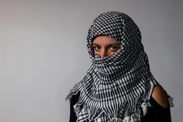 Green-eyed woman wearing a Palestinian scarf. Conflict concept