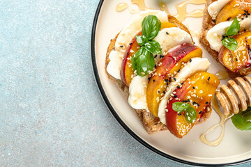 Italian Caprese salad with peaches, mozzarella on toast, snack, bruschetta, sandwich, copy space for text. top view