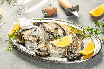 Oysters are protein rich and raw with lemon a delicacy on a light background top view. copy space