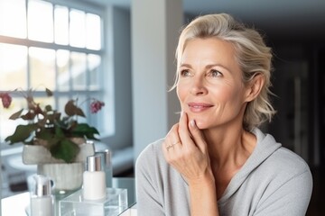 Attractive mature woman applying nourishing antiage face skin care cream treatment. AI Generated - obrazy, fototapety, plakaty