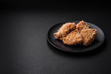 Delicious fresh crispy chicken nuggets on a dark concrete background