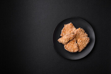 Delicious fresh crispy chicken nuggets on a dark concrete background