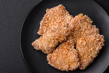 Delicious fresh crispy chicken nuggets on a dark concrete background
