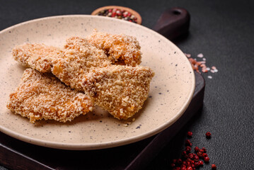 Delicious fresh crispy chicken nuggets on a dark concrete background
