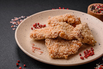 Delicious fresh crispy chicken nuggets on a dark concrete background